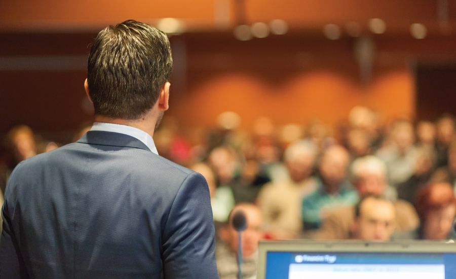 Public speaker delivering speech to room of listeners