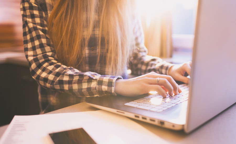 closeup of young adult female using computer to bank online