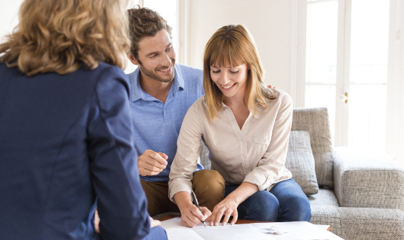 Young Couple with real estate agent eagerly buying a home