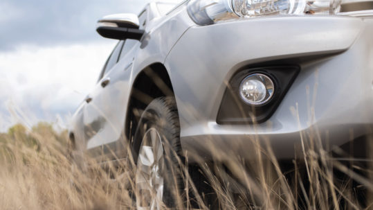 New silver SUV parked in tall grass